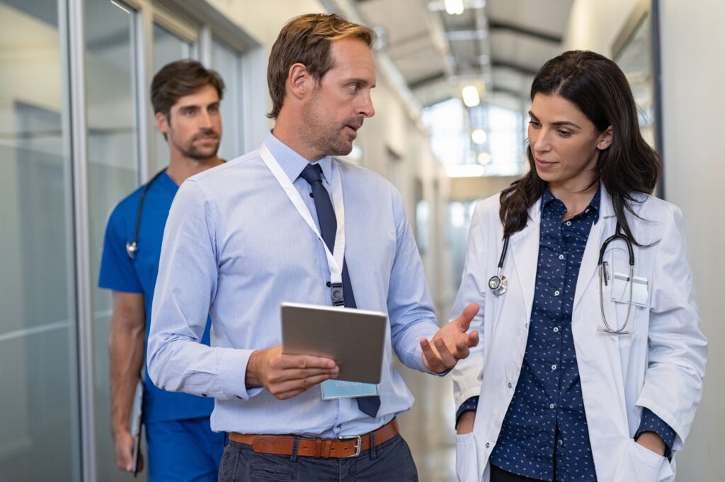 Accrediting team walking halls of hospital with staff leader