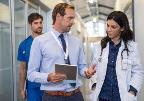 Accrediting team walking halls of hospital with staff leader