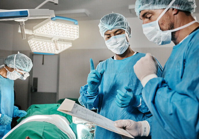 Surgeons reviewing procedural checklist before operating on patient.